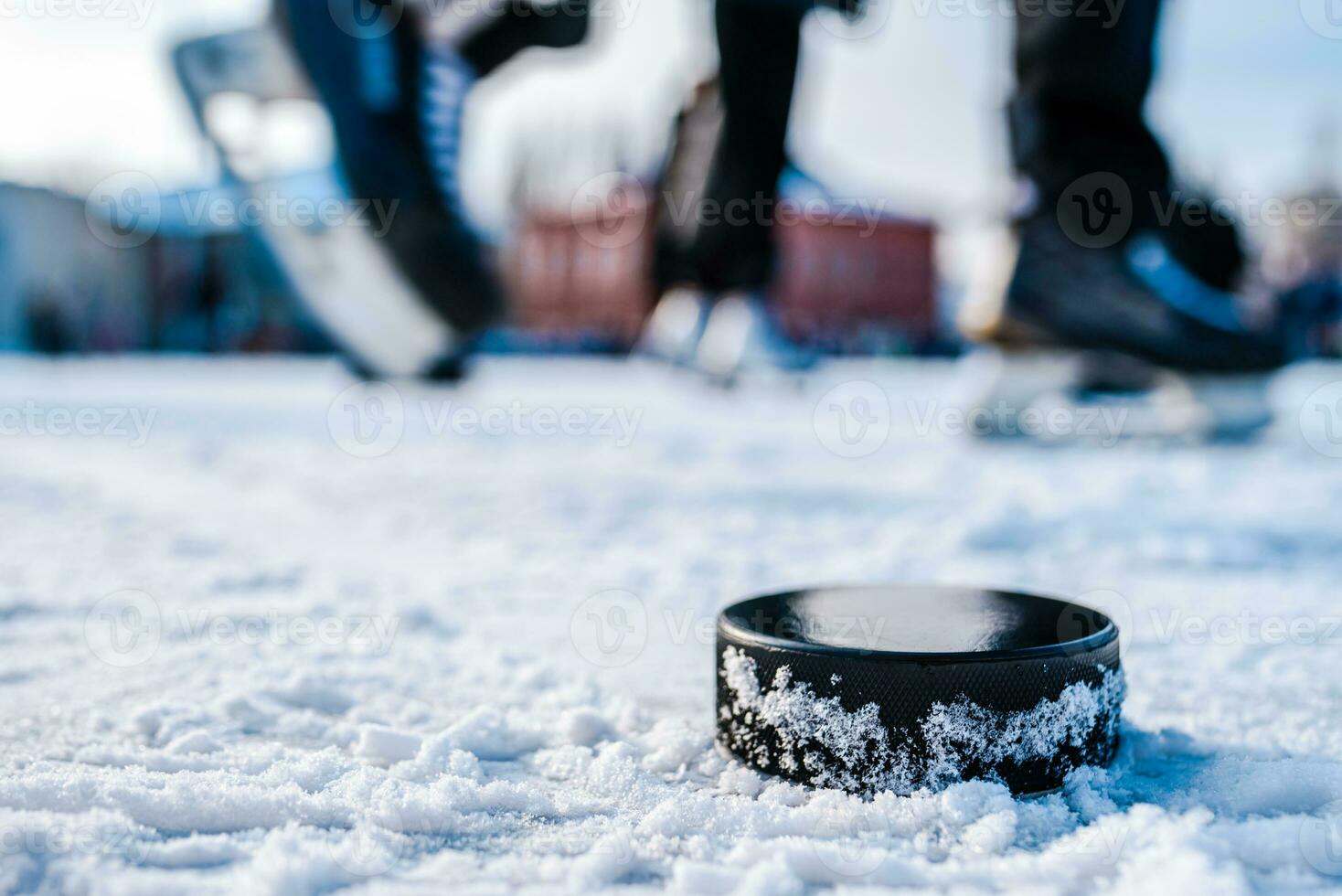 black hockey puck lies on ice at stadium photo