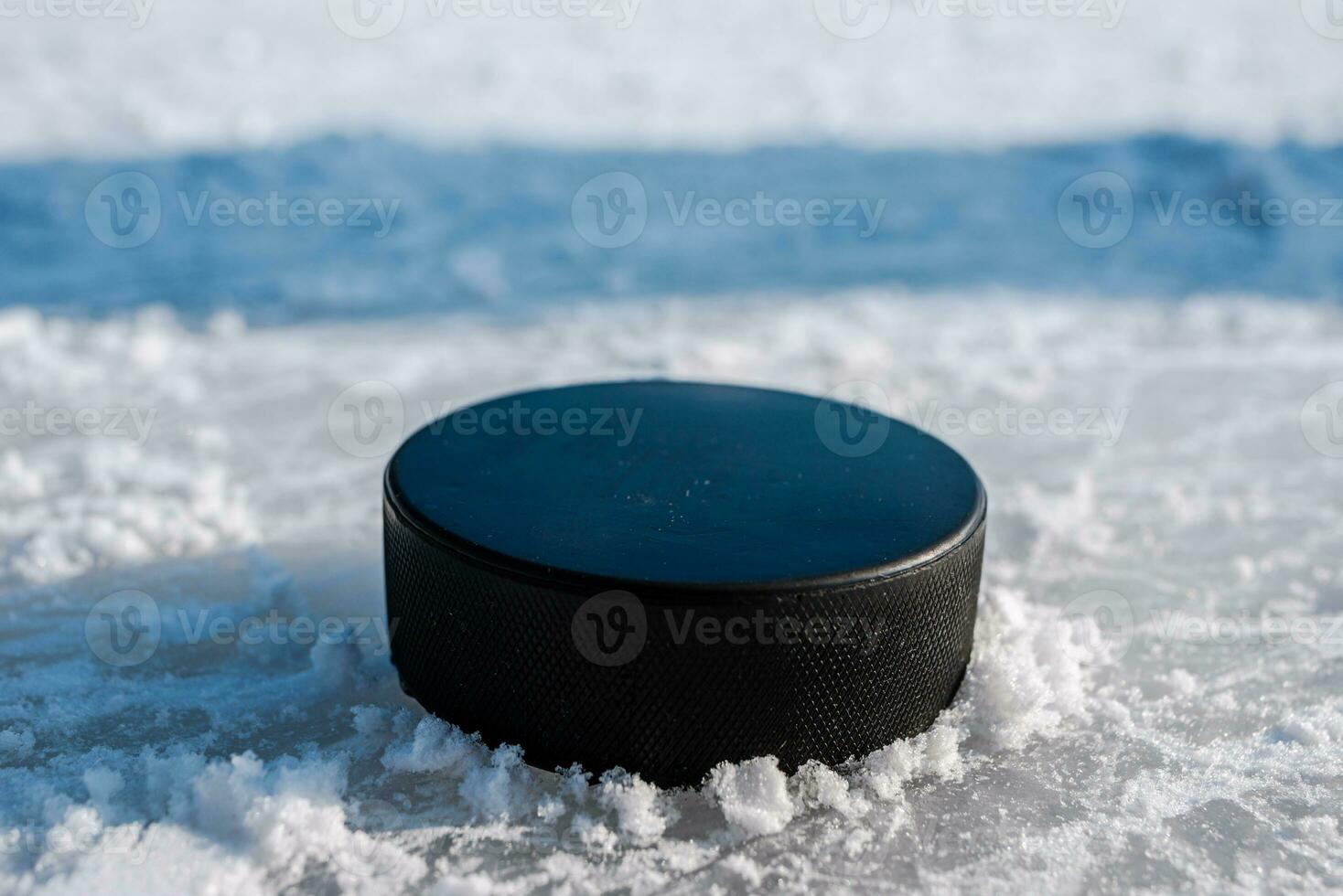 hockey puck lies on the snow close-up photo