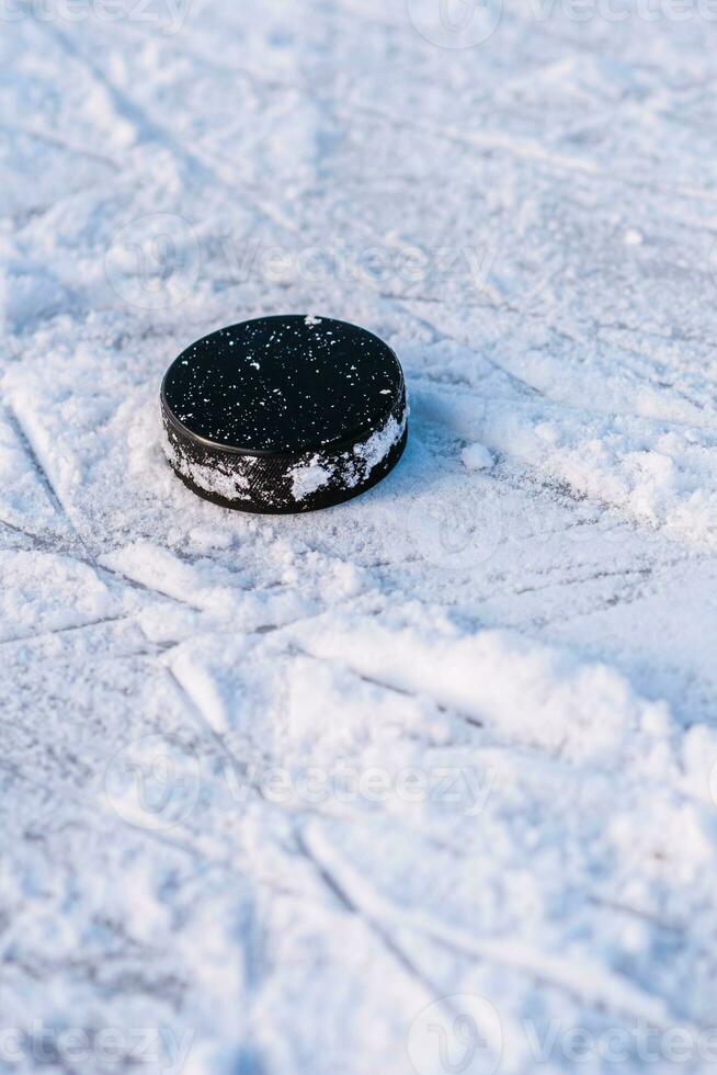 hockey puck lies on the snow close-up photo