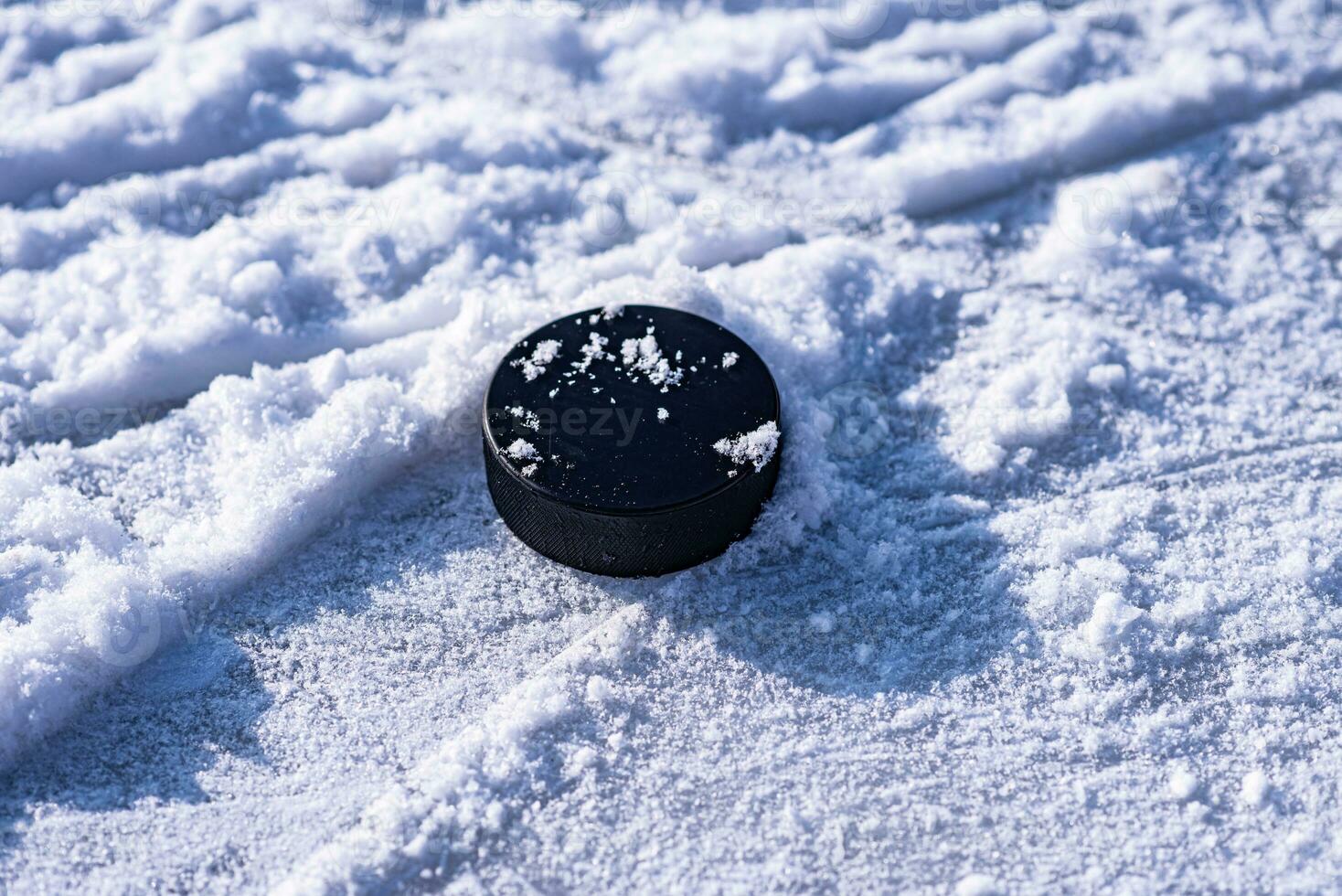 hockey puck lies on the snow close-up photo