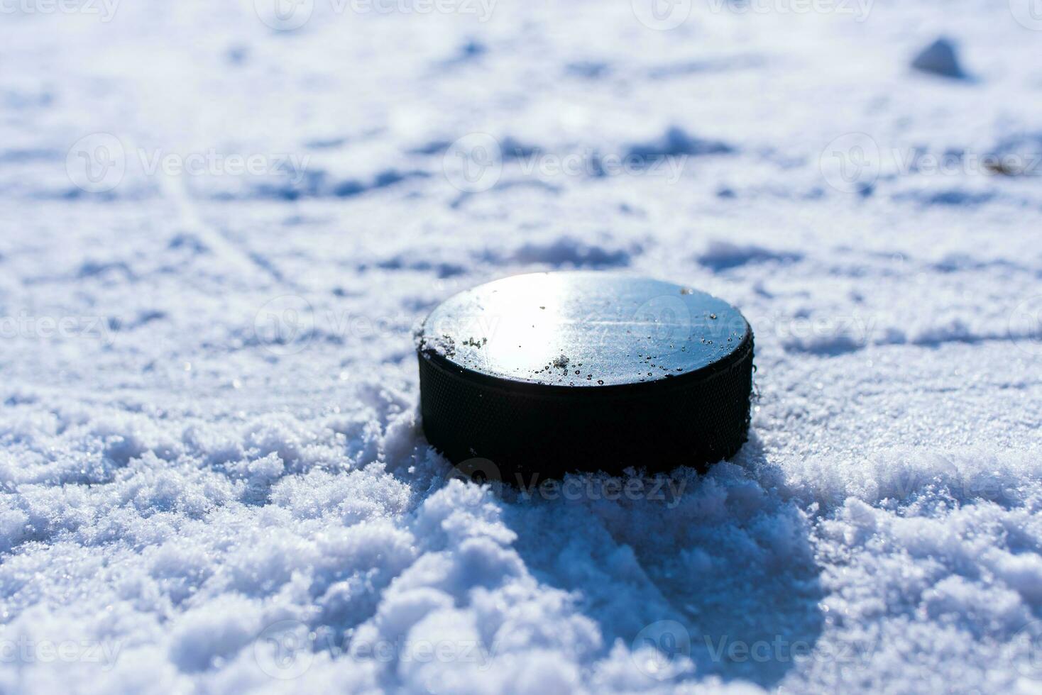 hockey puck lies on the snow close-up photo