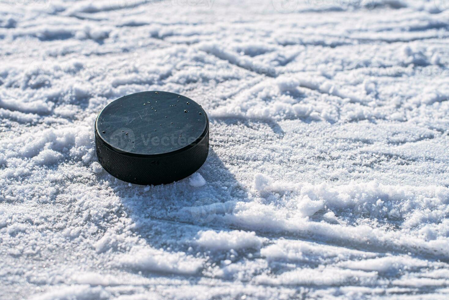 hockey puck lies on the snow close-up photo