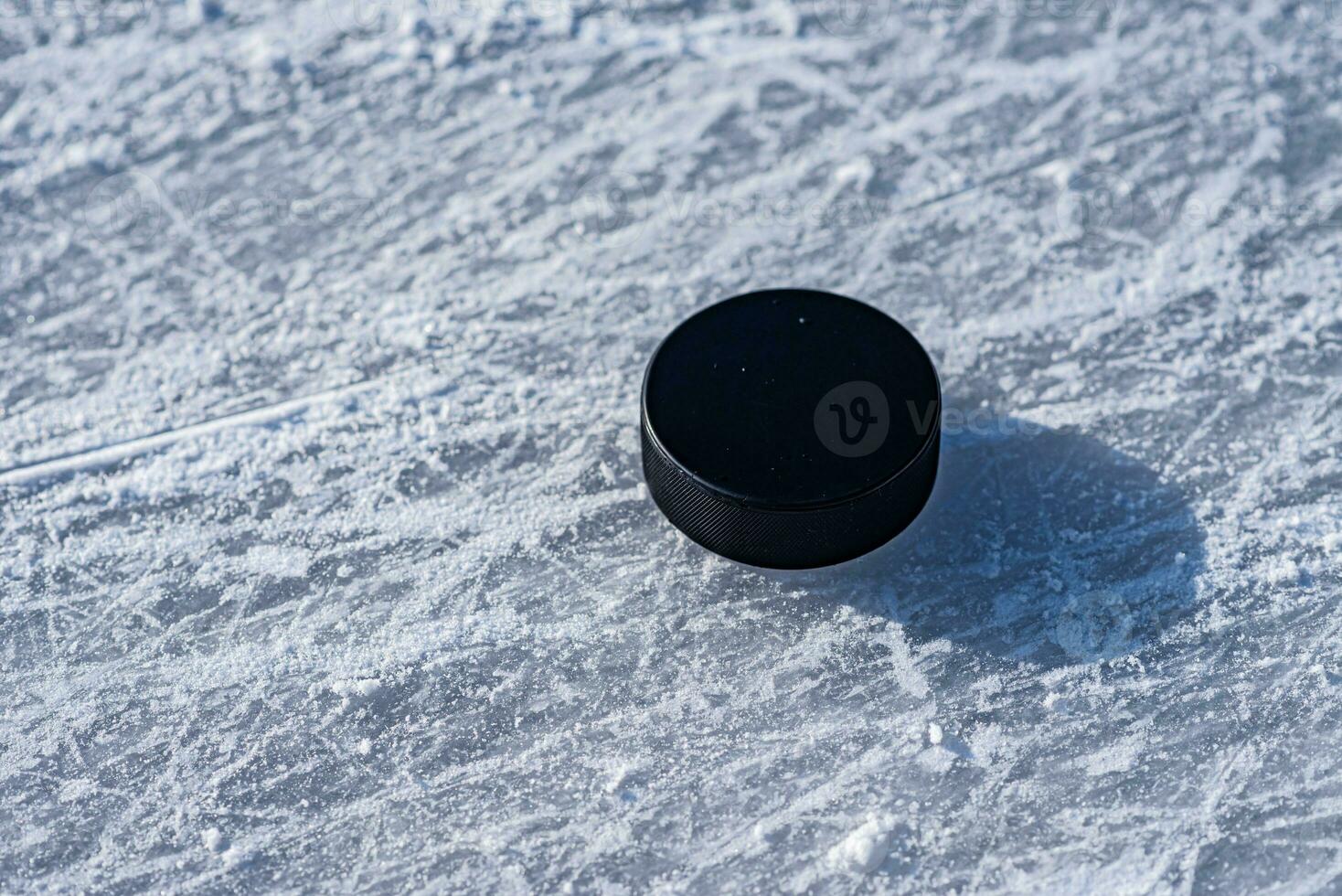 hockey puck lies on the snow close-up photo