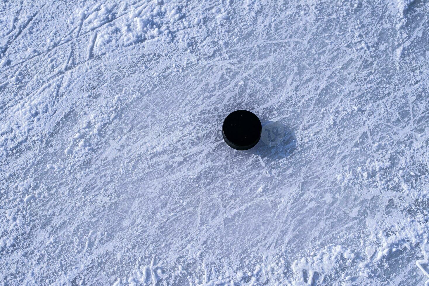 hockey puck lies on the snow close-up photo