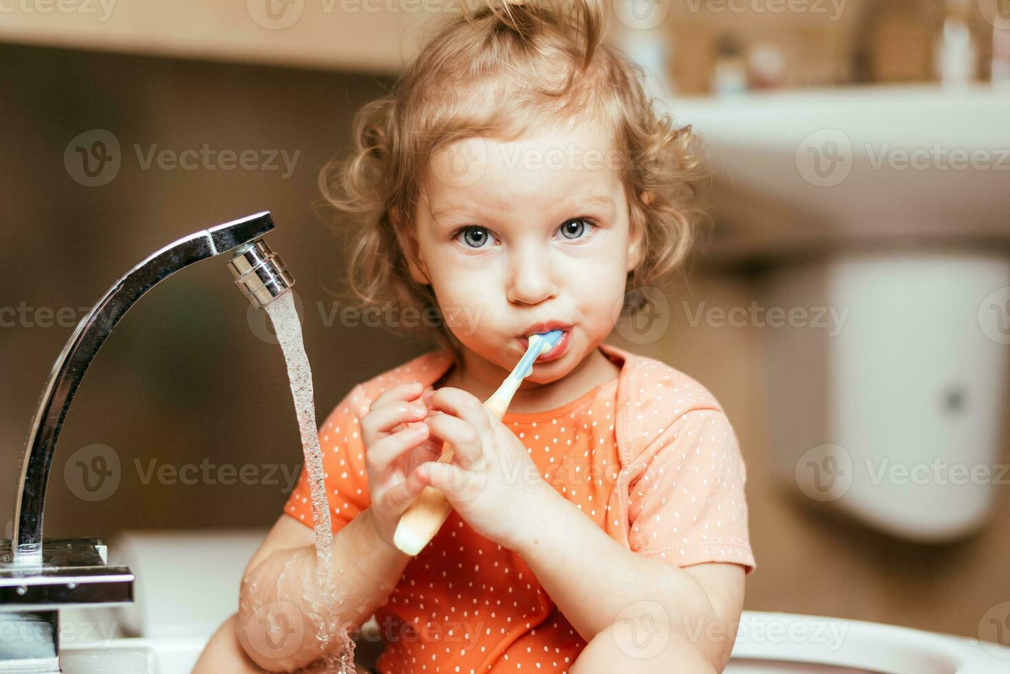 alegre contento niño cepillos su dientes en el Mañana en el bañera foto