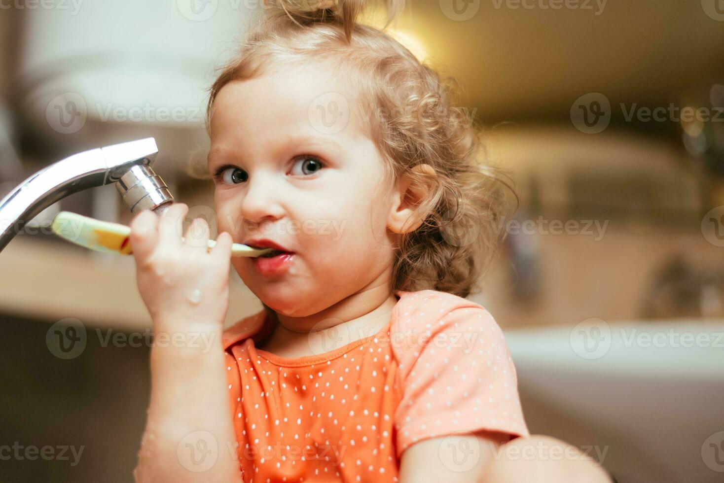 Happy child brushing his teeth in the morning in the bath photo