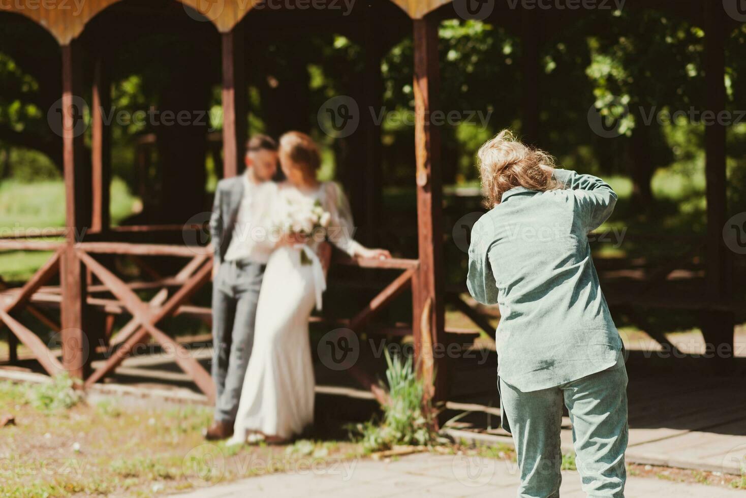 A wedding photographer photographs a couple in nature on a sunny day photo