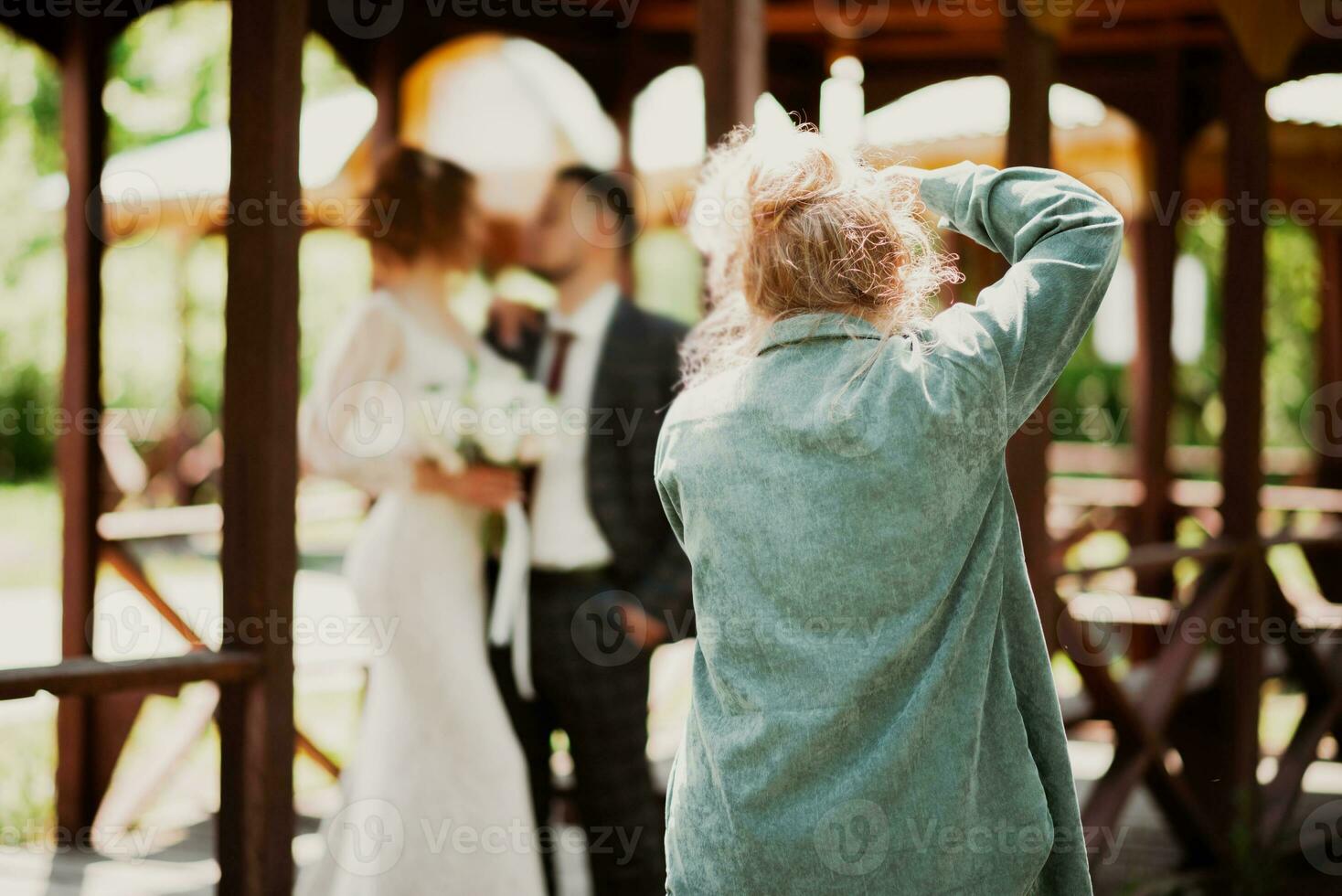 A wedding photographer photographs a couple in nature on a sunny day photo