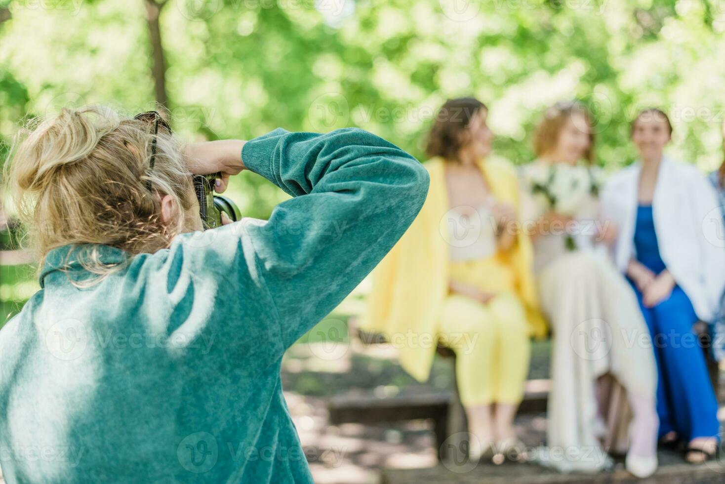 The wedding photographer photographs the guests of the bride and groom in nature photo