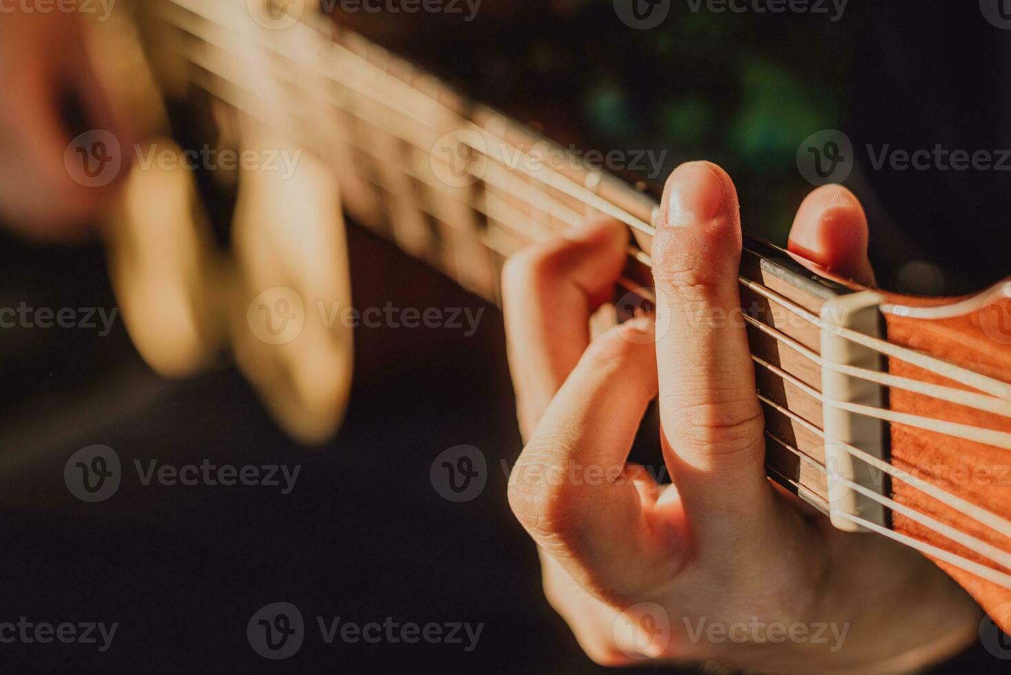 Man playing acoustic guitar and playing chords close-up photo