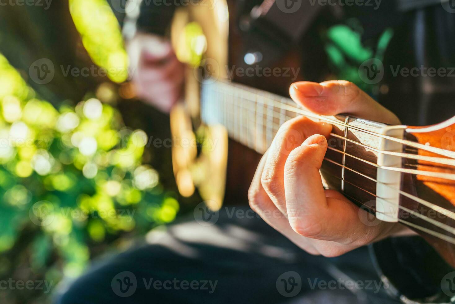 Man playing acoustic guitar and playing chords close-up photo