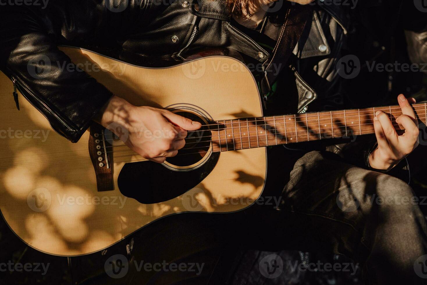 Man playing guitar in nature on a sunny day photo