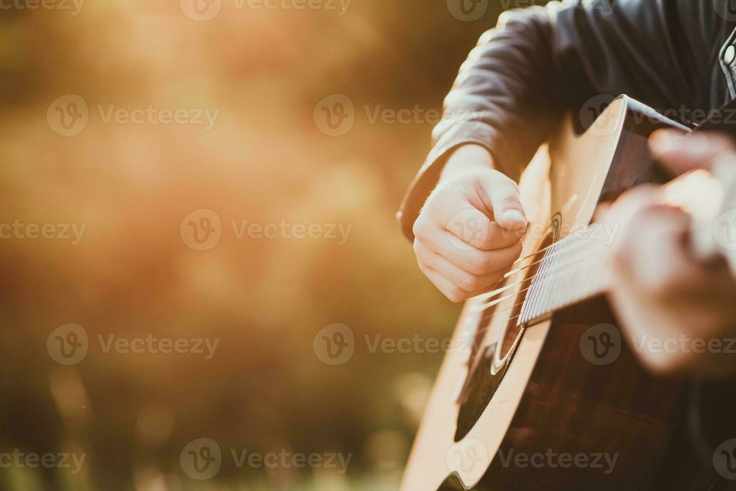 Man playing guitar in nature on a sunny day photo