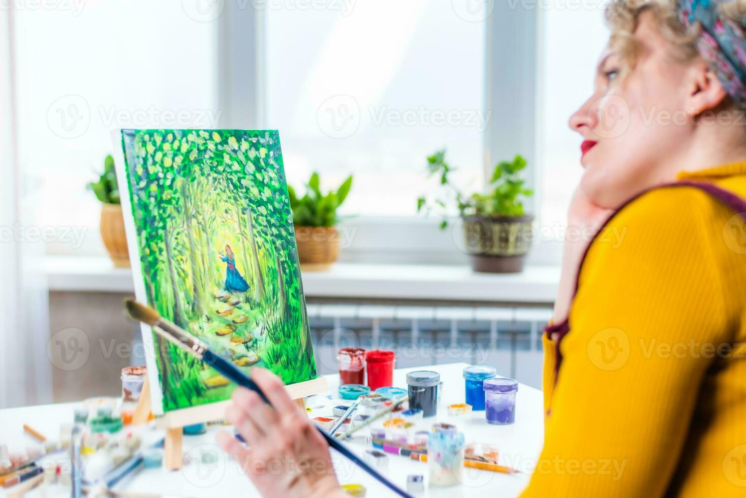 Portrait of an artist girl who creates a painting at home photo