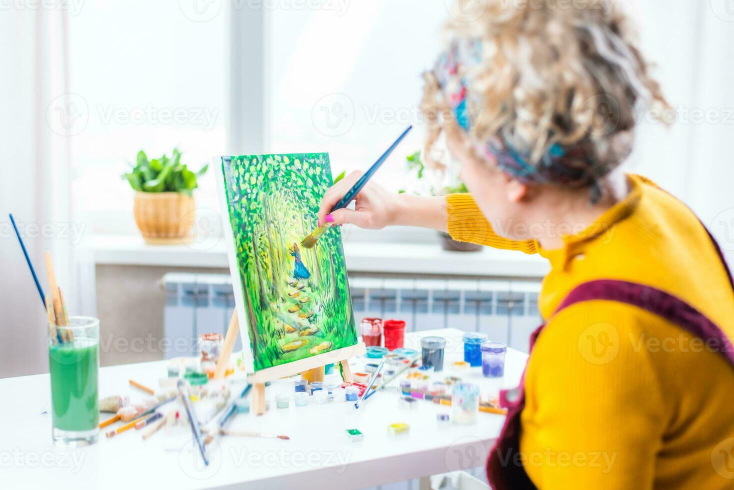 retrato de un artista niña quien crea un pintura a hogar foto