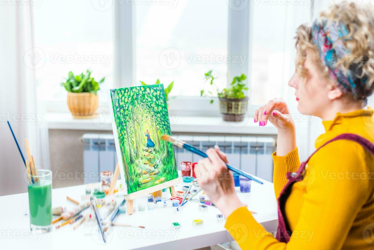 Portrait of an artist girl who creates a painting at home photo