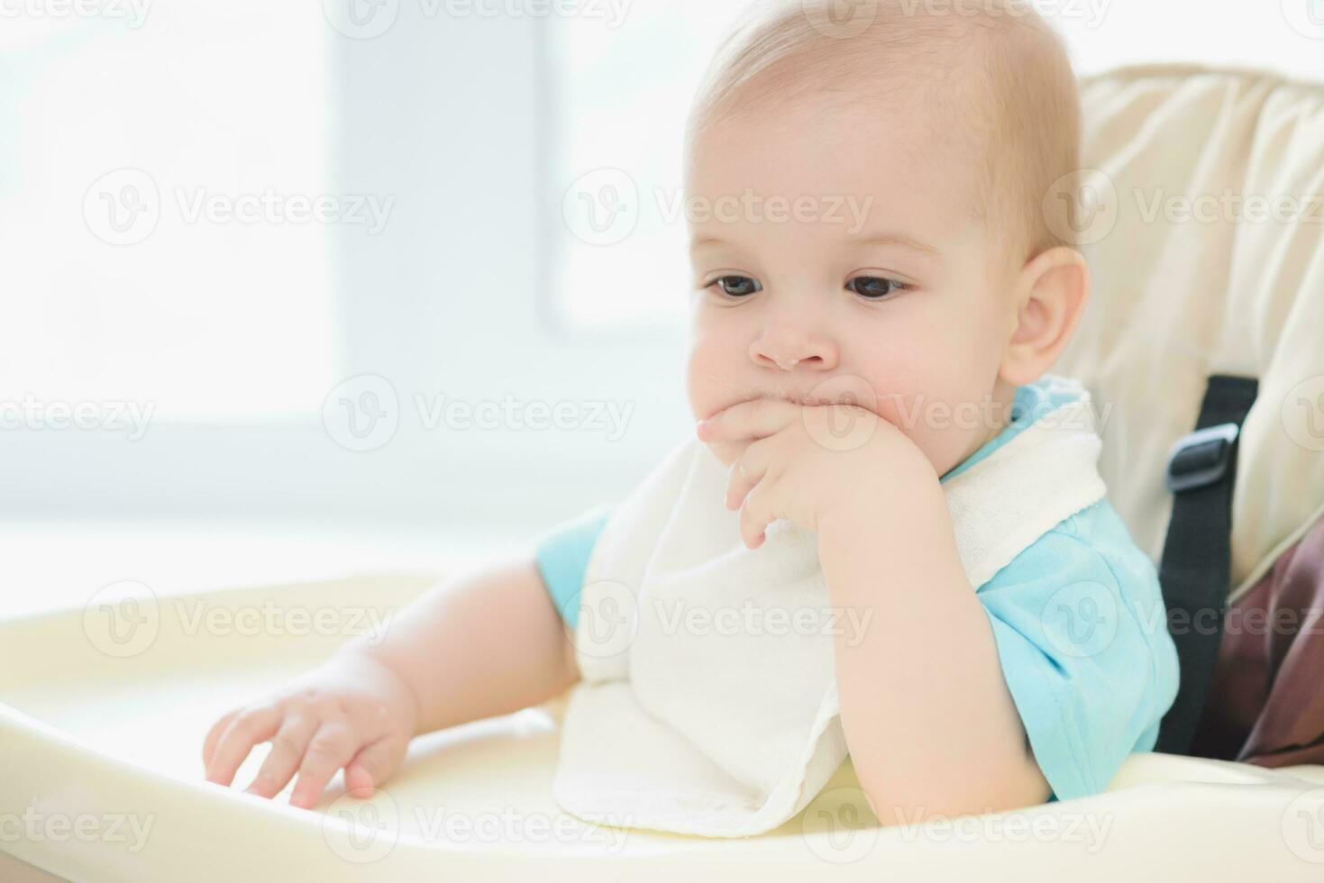 baby sitting on a chair and waiting for mother photo