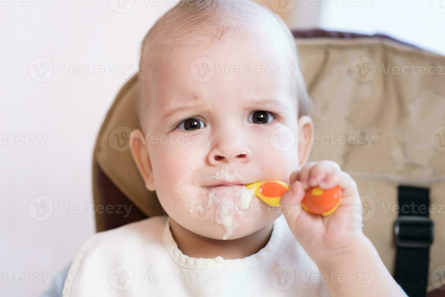 baby holding a spoon in his mouth photo