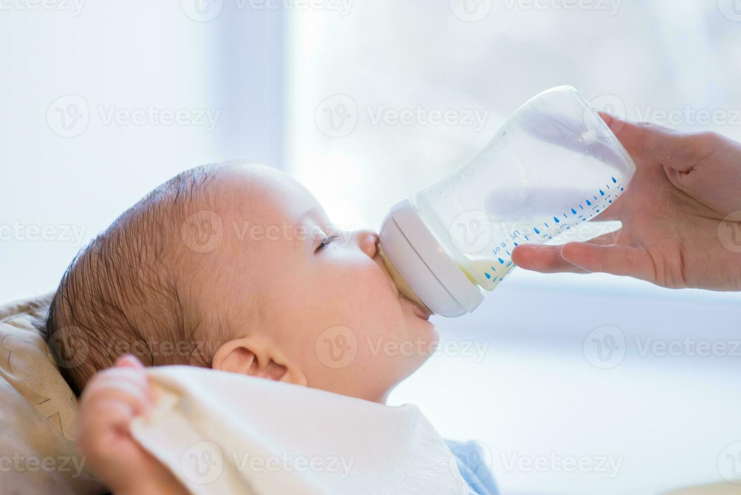 madre alimenta bebé desde un botella de Leche foto