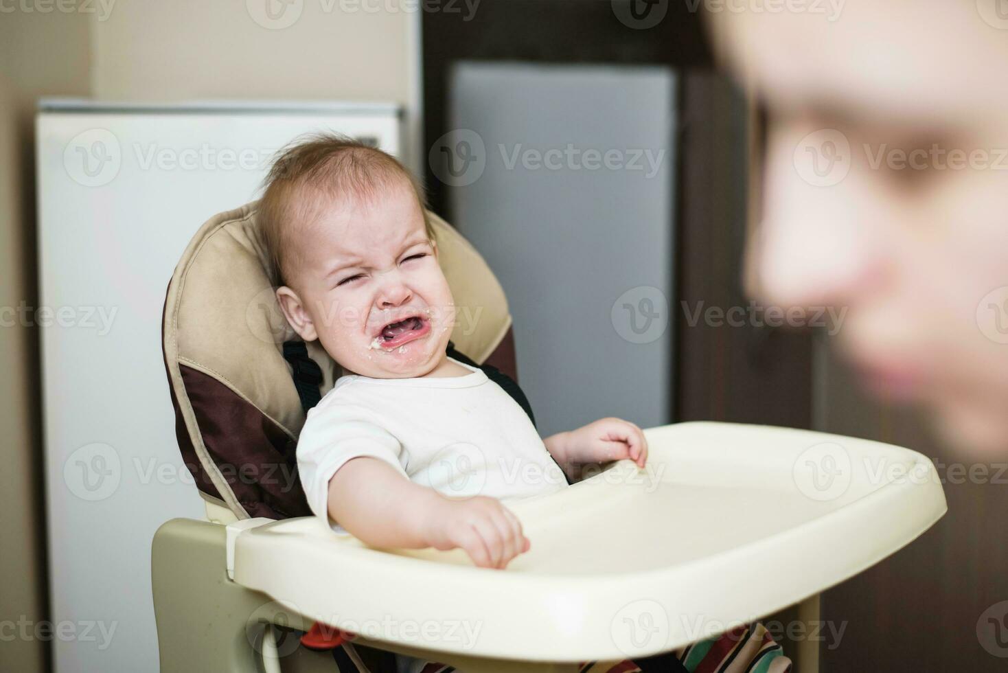 Mom feeds the baby who is naughty photo