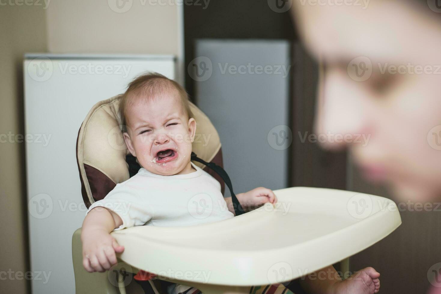 mamá alimenta el bebé quien es travieso foto