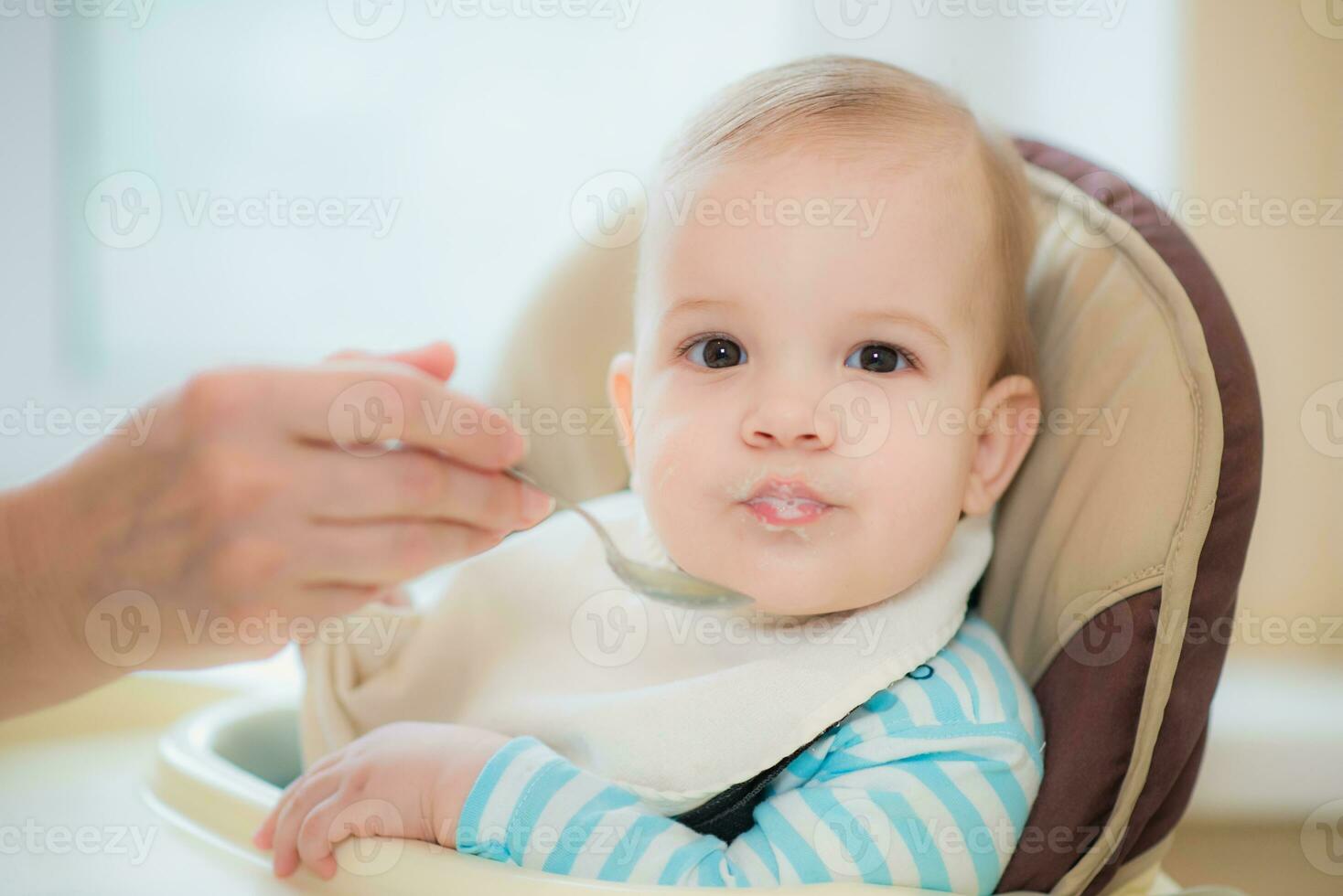 grandmother gives baby food from a spoon photo