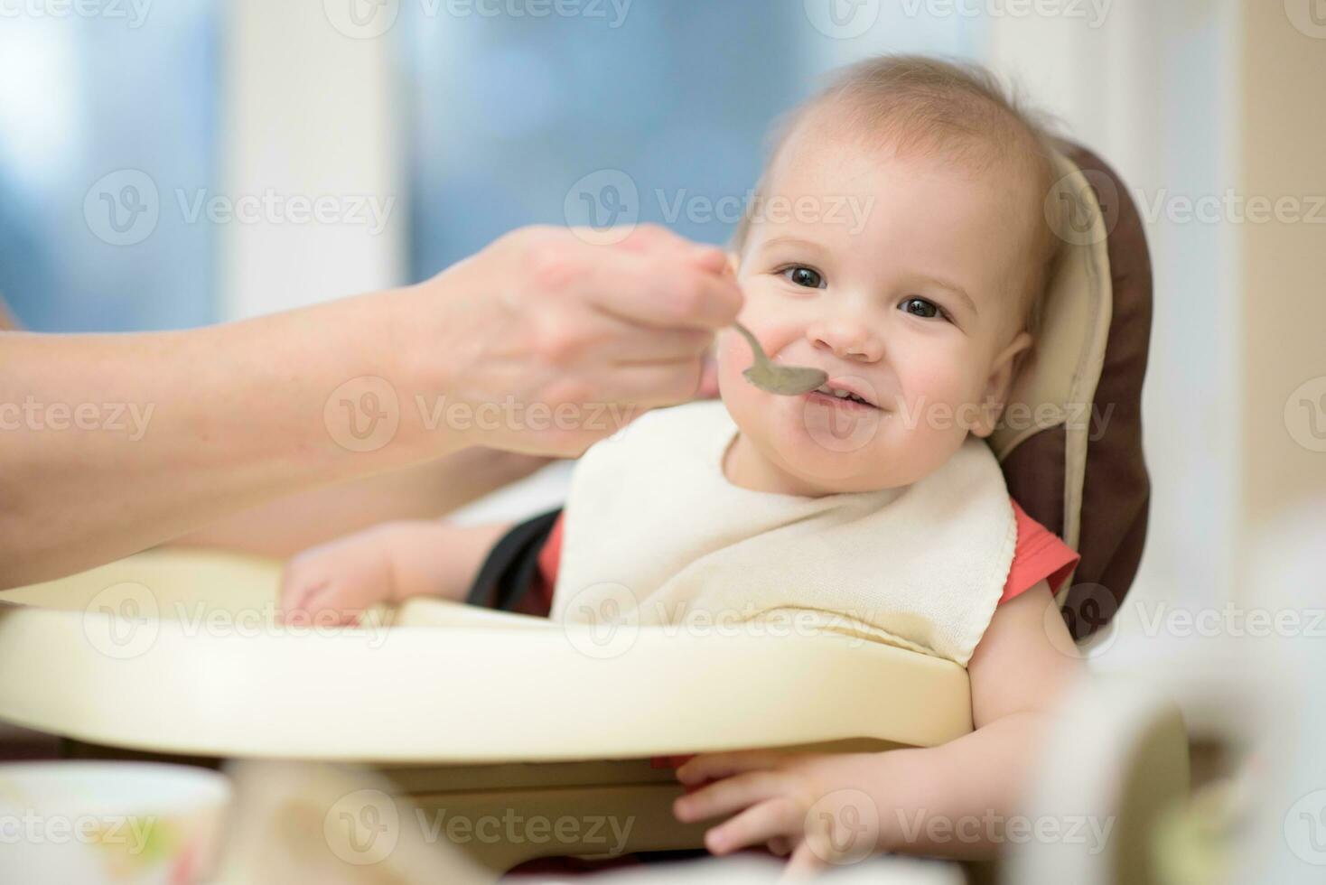 grandmother gives baby food from a spoon photo