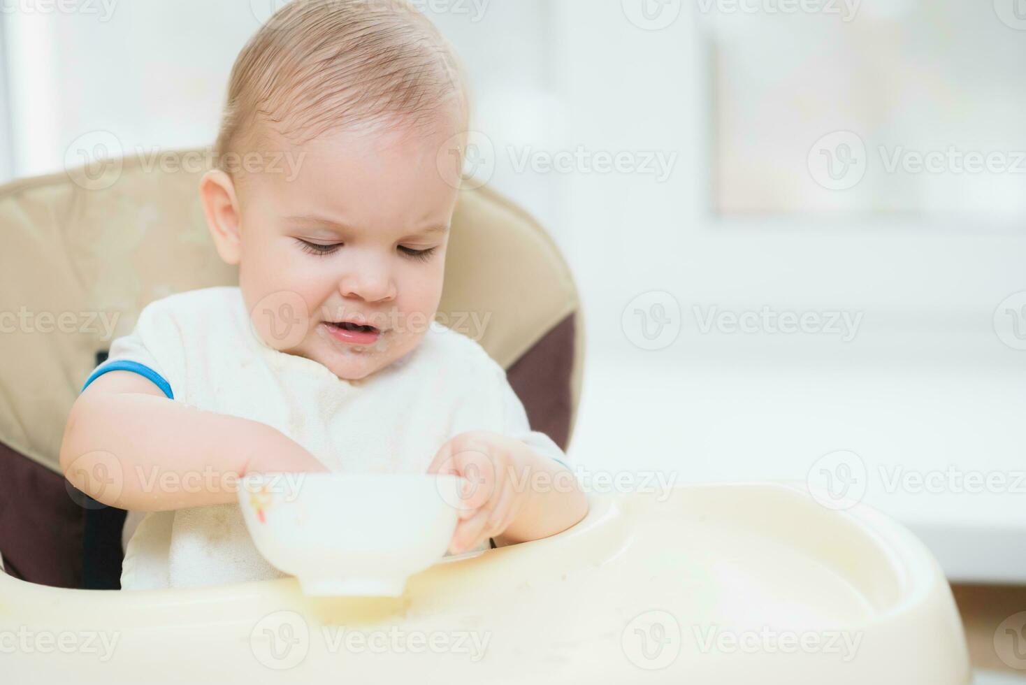 Kid eats porridge hands of the plate photo