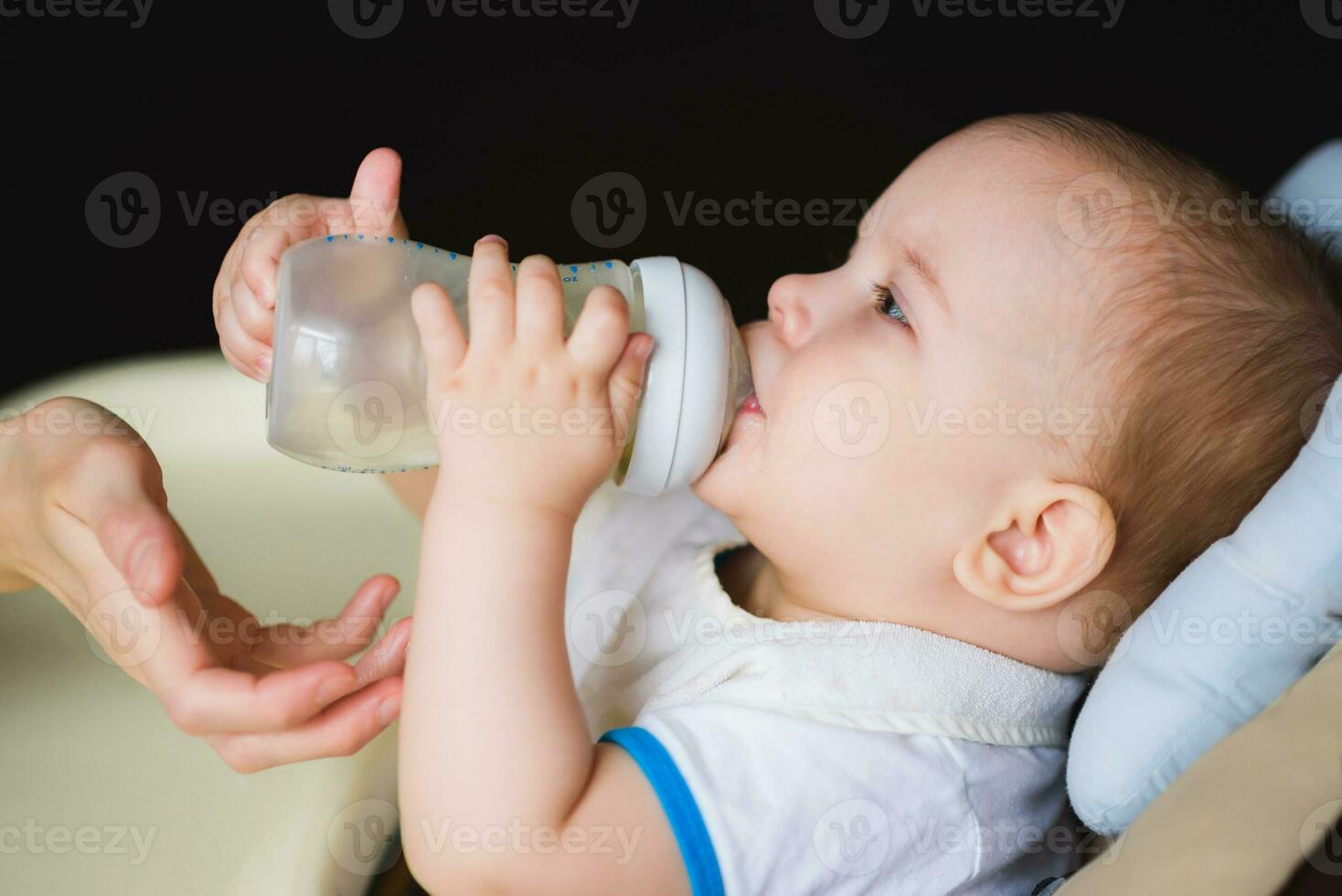 madre alimenta bebé desde un botella de Leche foto