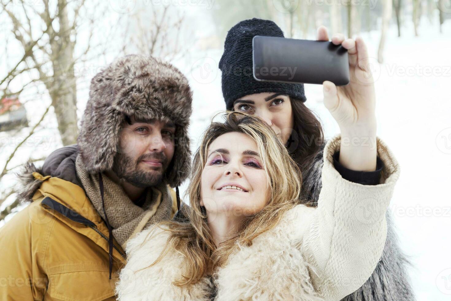 group of person taking selfie in winter forest photo