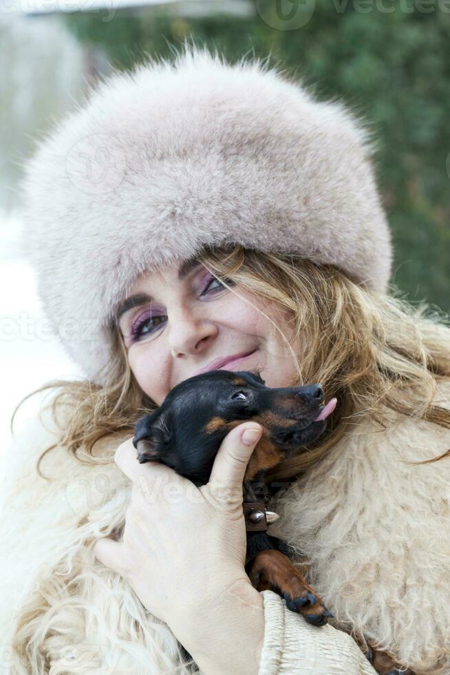 pretty lady cuddle her little dog in winter time photo