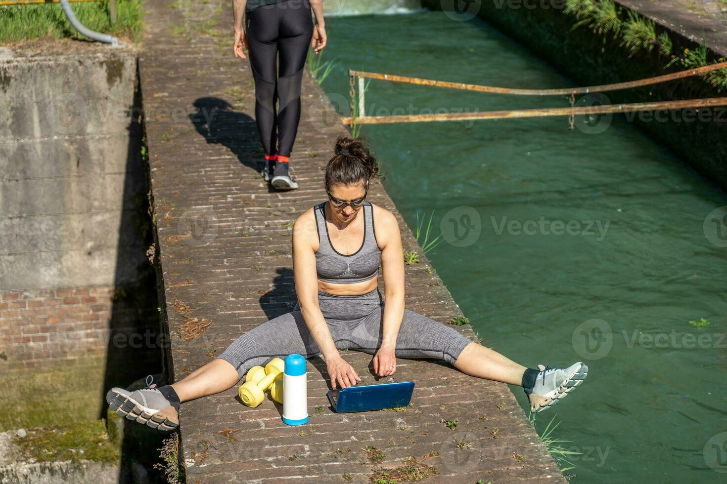 beautiful middle aged women planning workouts at the computer outdoors photo