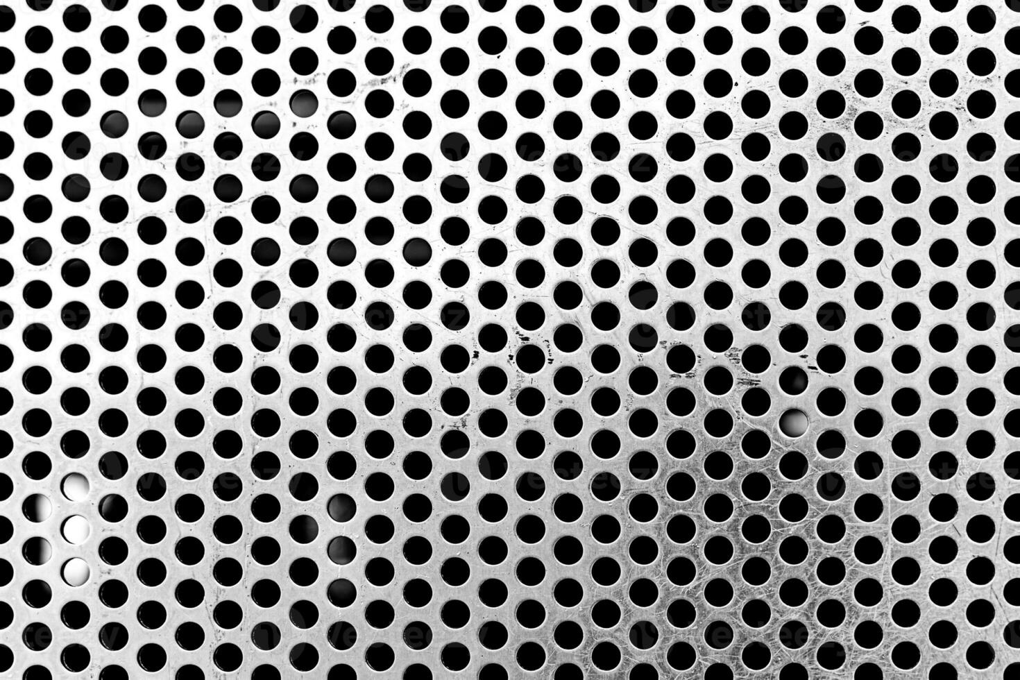 close up of a metal grate with small round holes - background for use as a texture - chrome textured background photo