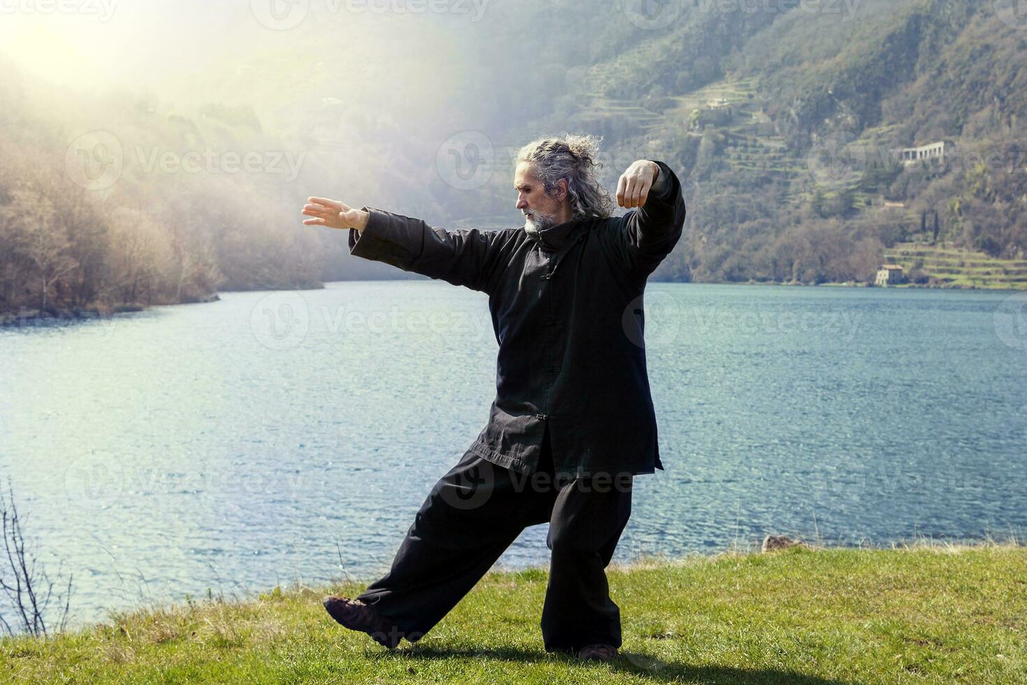 mature man practicing Tai Chi discipline outdoors photo