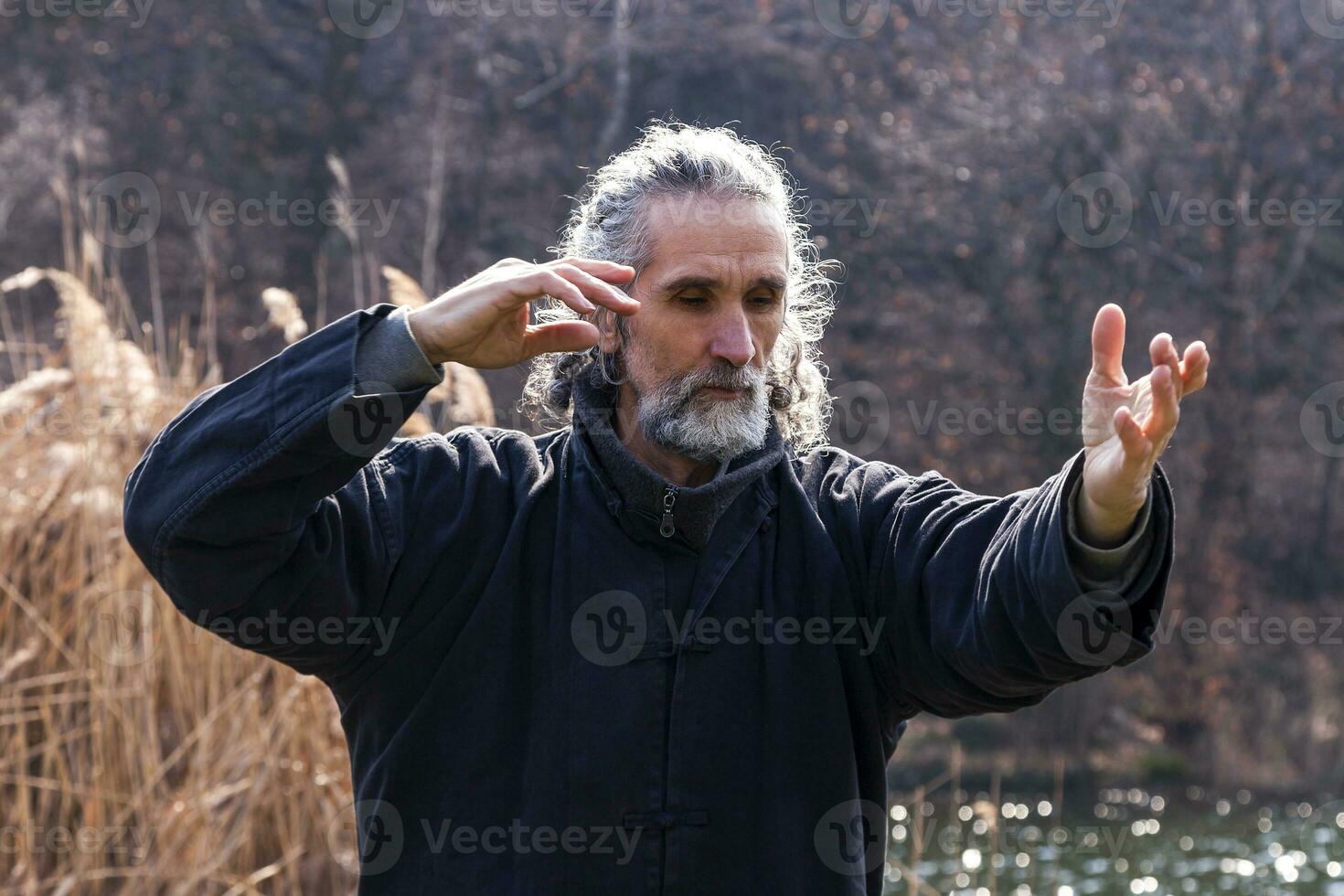 mature man practicing Tai Chi discipline outdoors photo