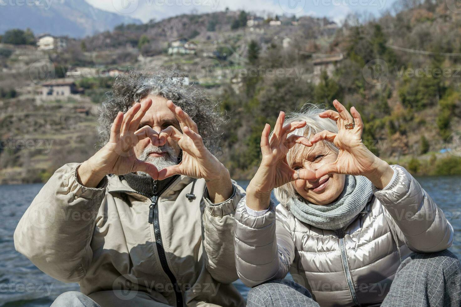 beautiful mature couple showing symbol of the heart photo