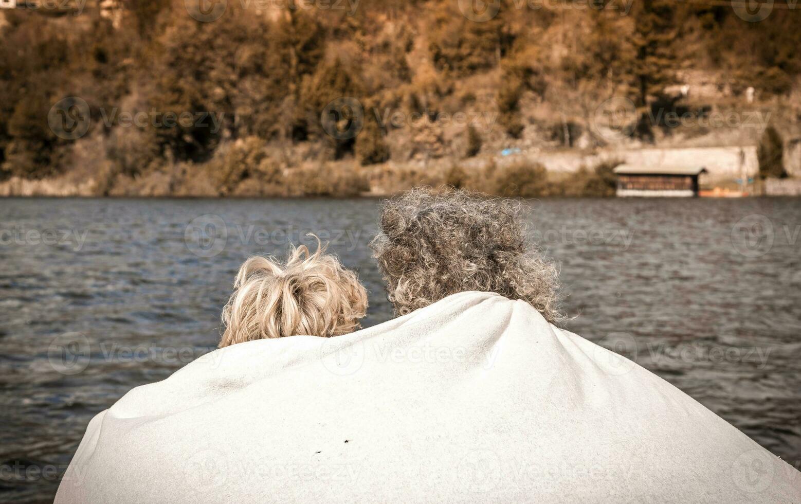 beautiful mature couple relaxing sitting on the dock photo