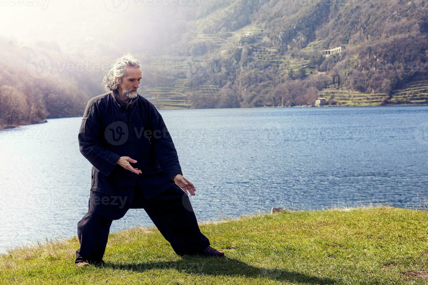 mature man practicing Tai Chi discipline outdoors photo