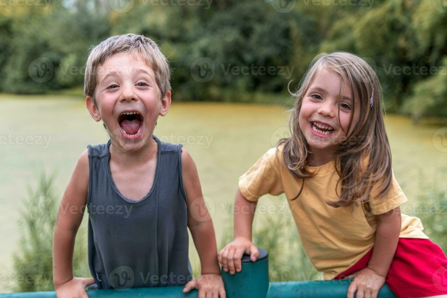 twins boys and girls have fun climbing metal pipes to play photo