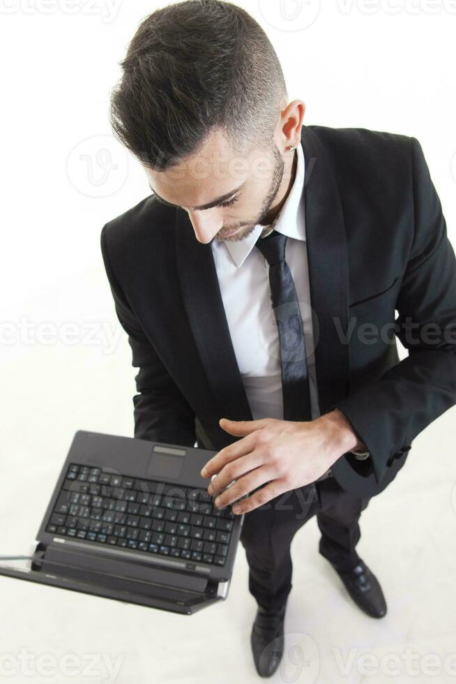 Portrait of young businessman with laptop isolated on white background photo