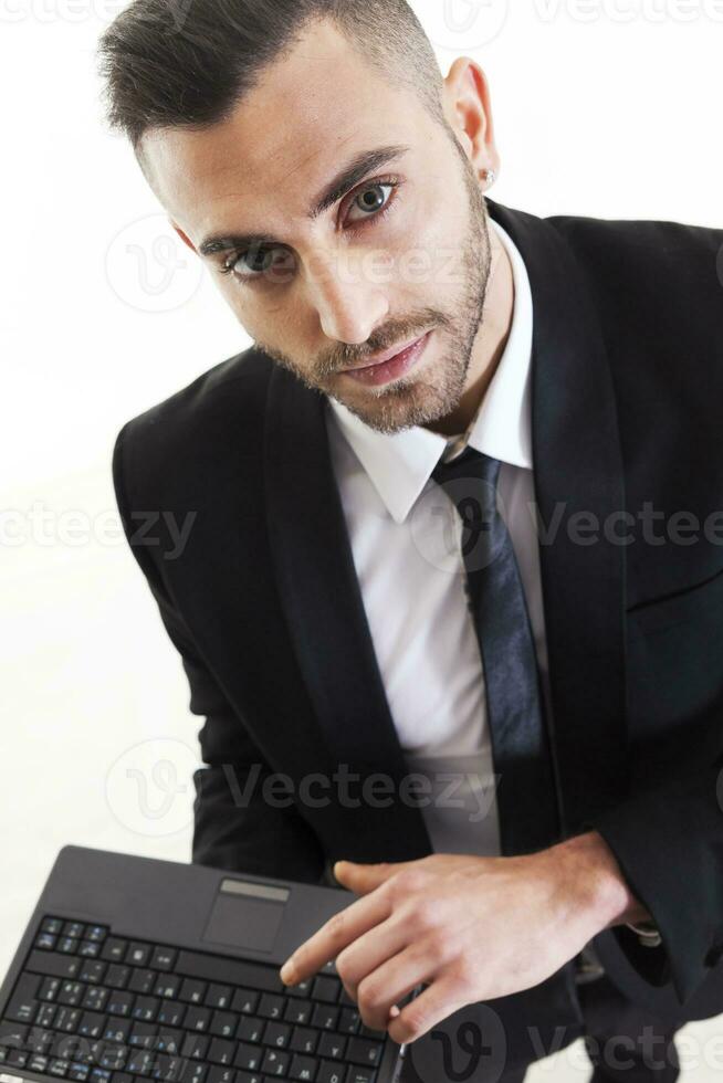 Portrait of young businessman with laptop isolated on white background photo