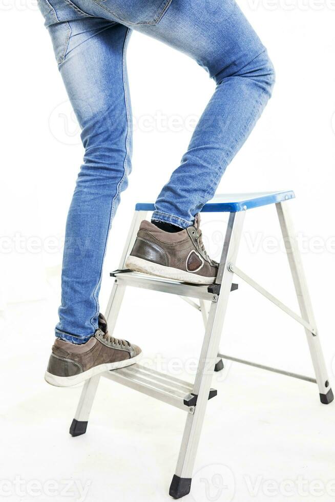 young worker climbing the ladder isolated on white photo