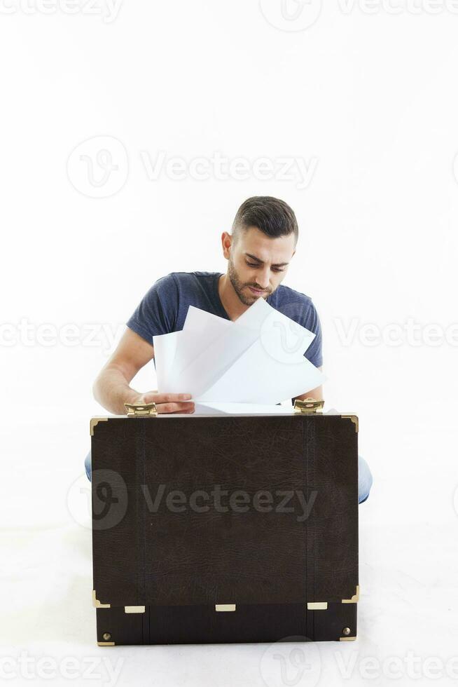 handsome young businessman takes sheets from a small briefcase photo