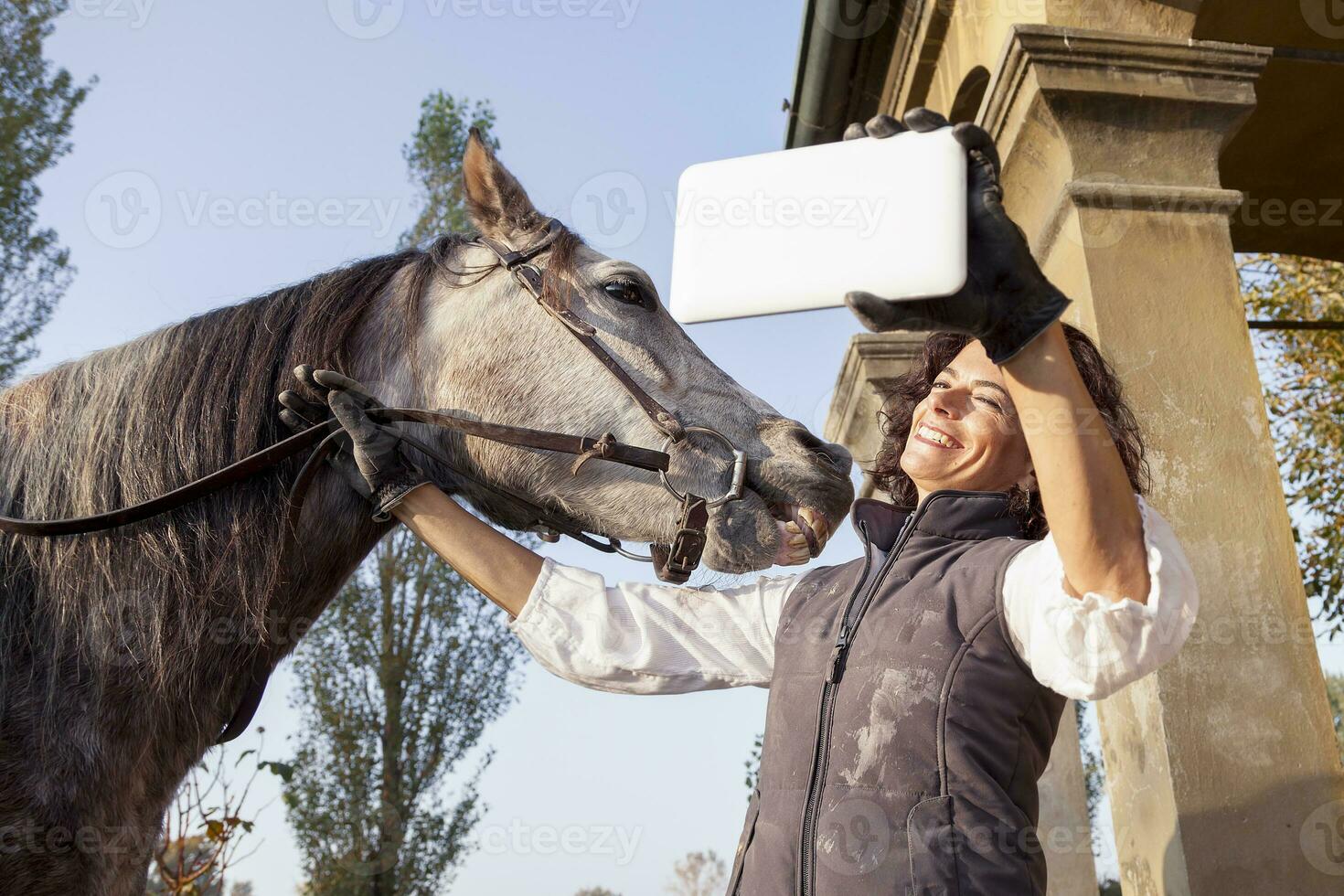 horsewoman takes a selfie with his horse to the country roads in autumn photo