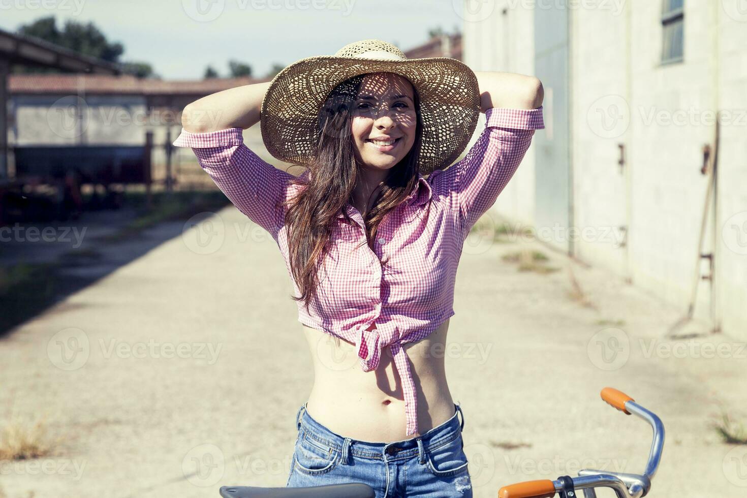 bonito joven mujer en bicicleta en un país la carretera foto