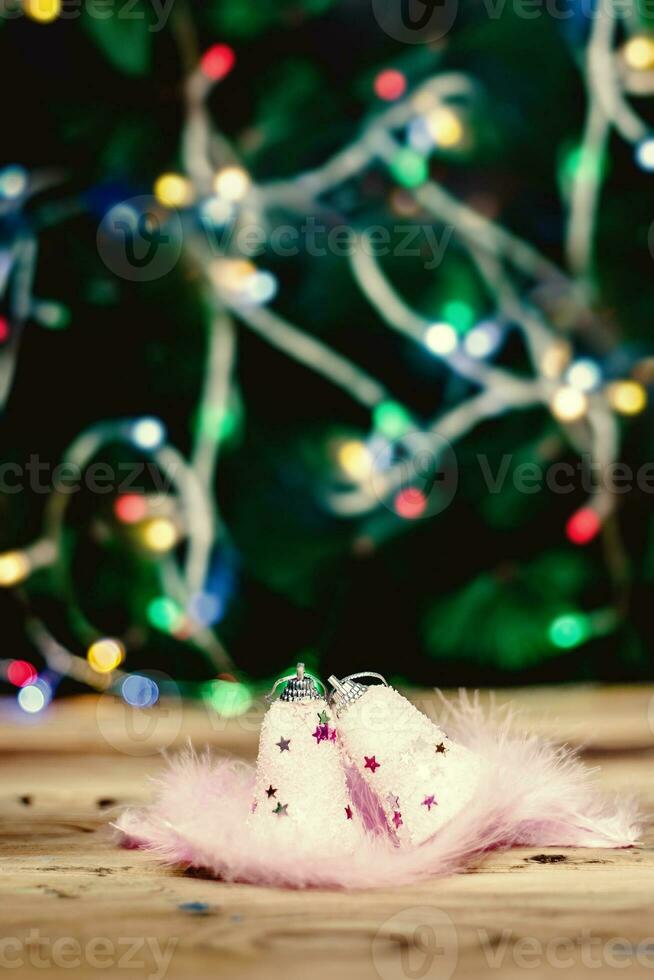 Cute pink Christmas toys with light pink feathers on wooden table photo