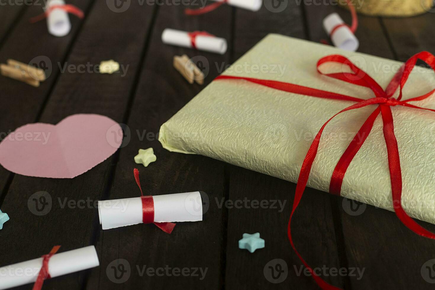 Romantic background. Gift box with rolled wishes paper gift pack on wooden board. photo