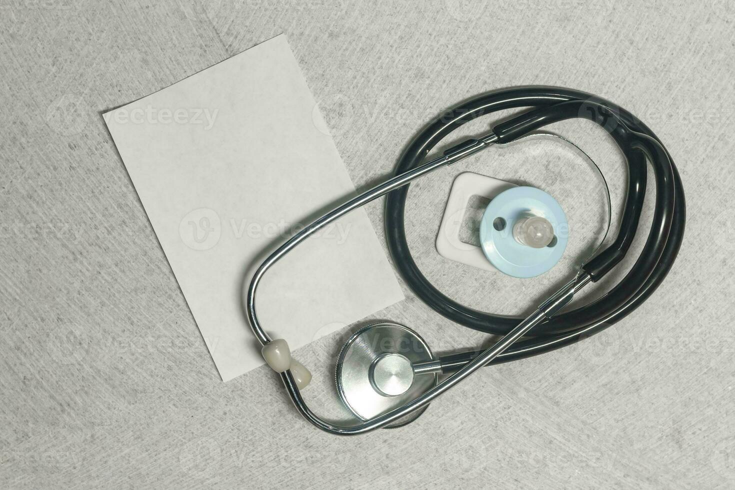 Stethoscope, phonendoscope and baby nipple on the marble. photo
