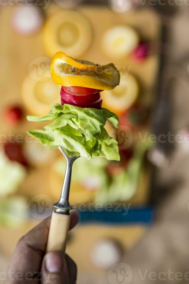 Hand holding fresh organic salad in fork photo