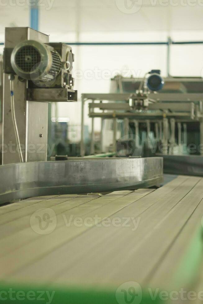 Glass bottles on the automatic conveyor line at the champagne, beer or wine factory. Plant for bottling alcoholic beverages. photo